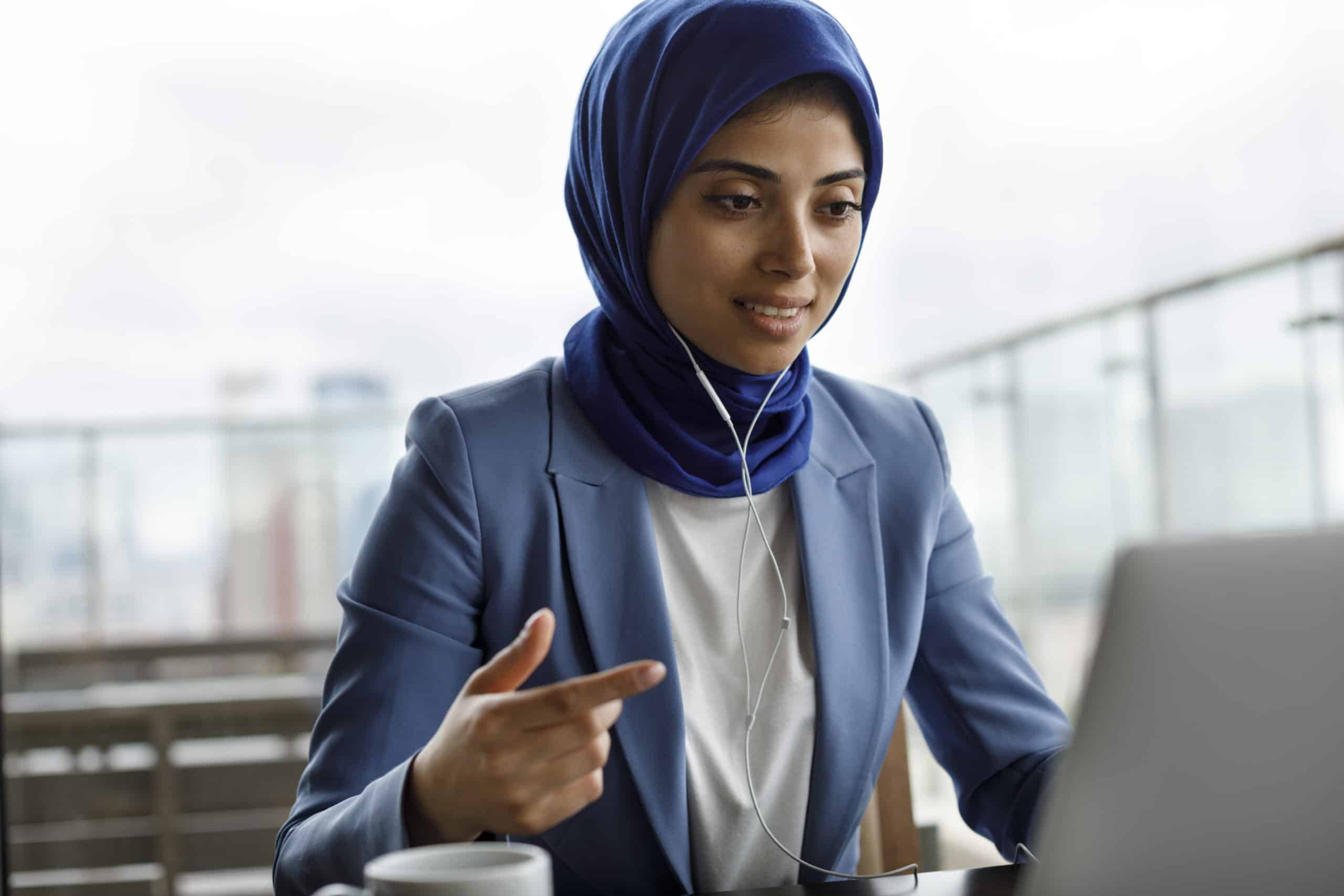 Young woman with headphones working on laptop